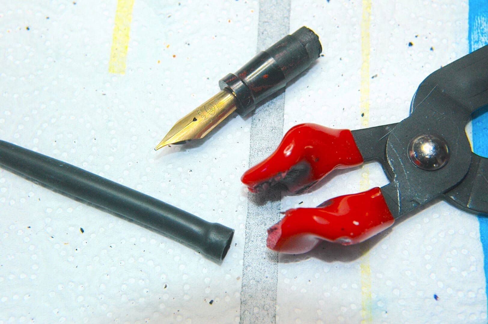 Fountain pen nib with pliers and tubing. Fountain pen nib with pliers and tubing.