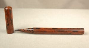 Wood-patterned pen with cap on plain background.