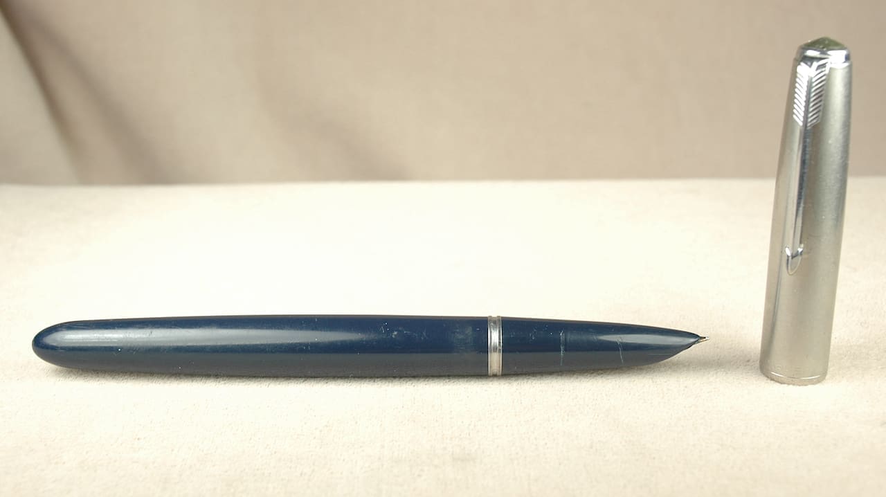 Blue fountain pen with silver cap detached.