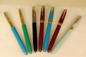Seven colorful fountain pens in a row.