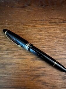 Black fountain pen on wooden surface.