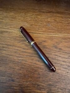 Fountain pen on wooden table surface.