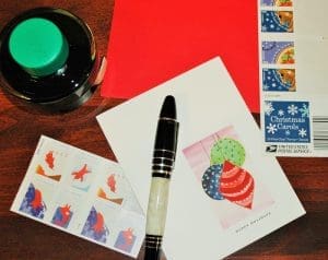 Ink, stamps, and card on wooden surface.