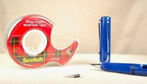 Tape dispenser and blue fountain pen.