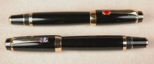 Two black fountain pens with gold trim.
