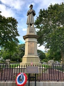 Statue of soldier in a park setting.
