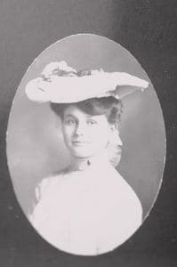 Woman in vintage hat, black-and-white portrait.