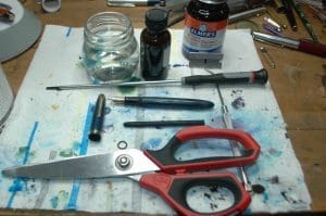 Scissors and tools on a cluttered workbench.
