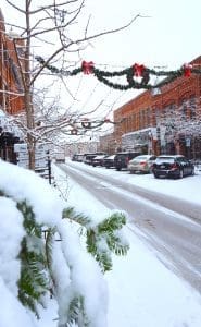 Snow-covered street with holiday decorations.