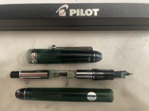 Pilot fountain pen disassembled on white surface.
