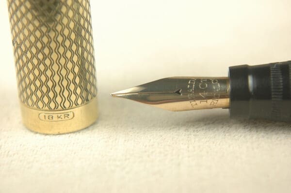 Gold fountain pen nib and cap close-up.