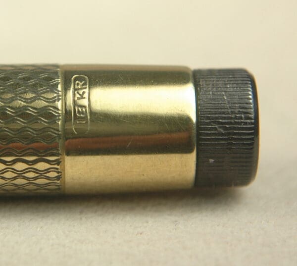 Brass vintage flashlight on a neutral background.