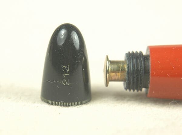 Black pen cap and red pen tip.