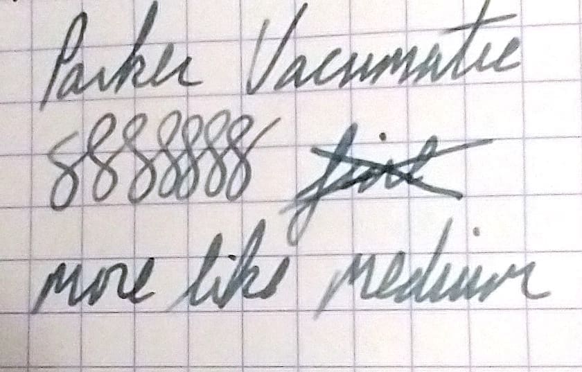 Close-up of handwritten notes on grid paper with crossed-out text.