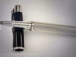 A sleek silver and black fountain pen on a white surface.